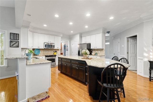11601 Shadow Run Ln, Glen Allen, VA 23059 - kitchen featuring stainless steel appliances, ornamental molding, backsplash, a breakfast bar, and white cabinets