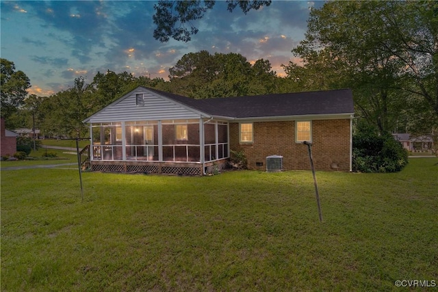5441 Claridge Dr, Chesterfield, VA 23832 - back of property at dusk featuring a sunroom, a lawn, and brick siding