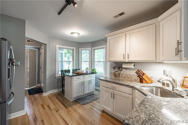 3909 Foxfield Ter, Henrico, VA 23233 - kitchen featuring freestanding refrigerator, a sink, light wood-style flooring, light stone countertops, and baseboards