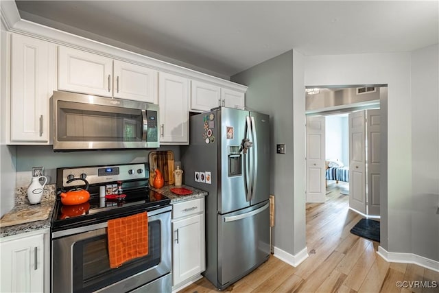 3909 Foxfield Ter, Henrico, VA 23233 - kitchen with stainless steel appliances, light wood-style flooring, baseboards, white cabinetry, and light stone counters