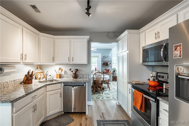 3909 Foxfield Ter, Henrico, VA 23233 - kitchen with stainless steel appliances, a sink, light wood-style flooring, white cabinets, and light stone counters