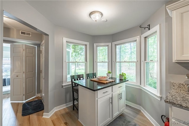 3909 Foxfield Ter, Henrico, VA 23233 - kitchen with light wood-style floors, white cabinets, baseboards, and dark stone countertops
