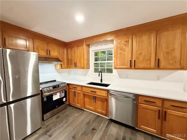 4608 Stoney Creek Pkwy, Chester, VA 23831 - kitchen featuring appliances with stainless steel finishes, under cabinet range hood, a sink, wood finished floors, and brown cabinetry