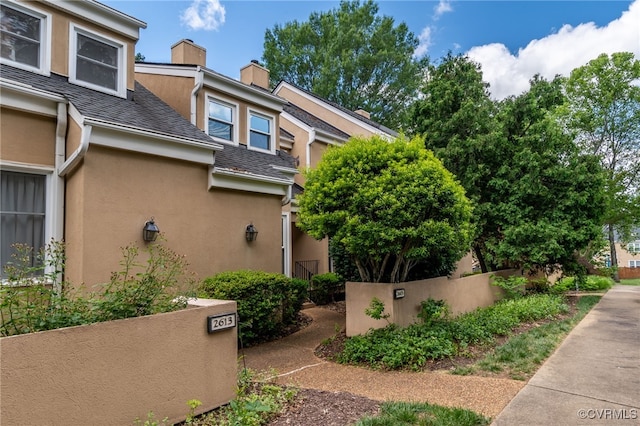 2615 Towngate Ct, Henrico, VA 23233 - view of home's exterior with stucco siding, a chimney, and roof with shingles