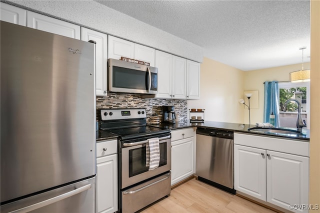 2615 Towngate Ct, Henrico, VA 23233 - kitchen featuring stainless steel appliances, a sink, light wood-style flooring, white cabinets, and a textured ceiling