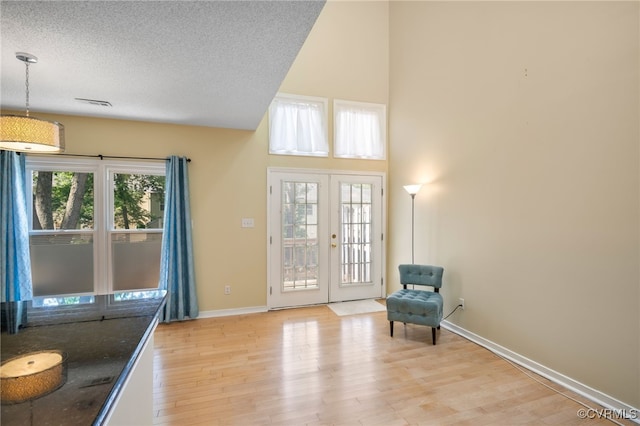 2615 Towngate Ct, Henrico, VA 23233 - unfurnished room featuring light wood-style floors, french doors, baseboards, a towering ceiling, and a textured ceiling