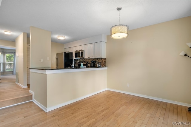 2615 Towngate Ct, Henrico, VA 23233 - kitchen with stainless steel appliances, a peninsula, dark countertops, and light wood finished floors