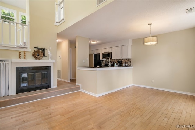 2615 Towngate Ct, Henrico, VA 23233 - unfurnished living room featuring light wood-style flooring, baseboards, and a glass covered fireplace