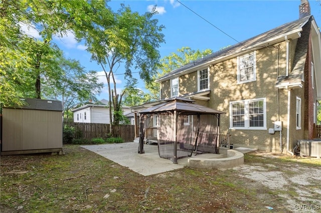 2920 Hawthorne Ave, Richmond, VA 23222 - back of property featuring a gazebo, a patio area, a fenced backyard, central AC, and a chimney