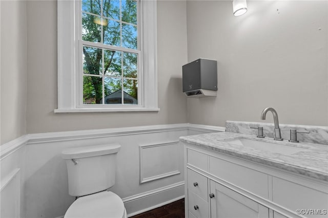 2920 Hawthorne Ave, Richmond, VA 23222 - bathroom with a wainscoted wall, vanity, toilet, wood finished floors, and a decorative wall