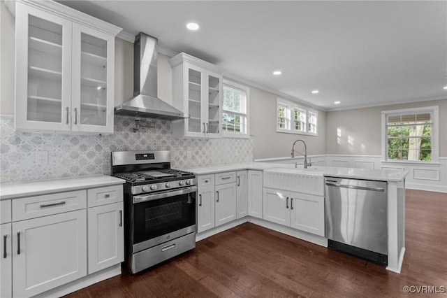 2920 Hawthorne Ave, Richmond, VA 23222 - kitchen featuring appliances with stainless steel finishes, wall chimney range hood, a peninsula, dark wood finished floors, and light countertops