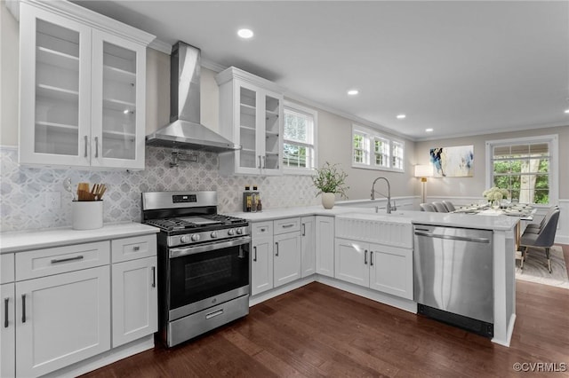 2920 Hawthorne Ave, Richmond, VA 23222 - kitchen featuring appliances with stainless steel finishes, wall chimney exhaust hood, a peninsula, dark wood-type flooring, and recessed lighting
