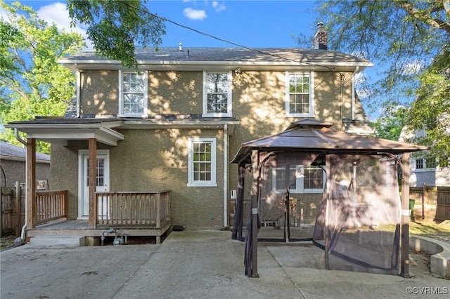 2920 Hawthorne Ave, Richmond, VA 23222 - back of property with a patio area, a gazebo, a chimney, stucco siding, and a wooden deck