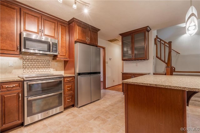 13100 Spring Trace Pl, Midlothian, VA 23112 - kitchen with stainless steel appliances, backsplash, glass insert cabinets, and brown cabinets