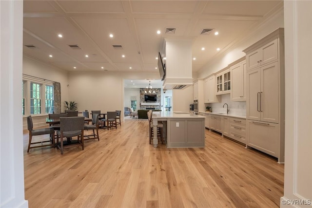 9008 Mirage Mews, Richmond, VA 23238 - kitchen featuring light countertops, open floor plan, light wood-style floors, a breakfast bar, and crown molding