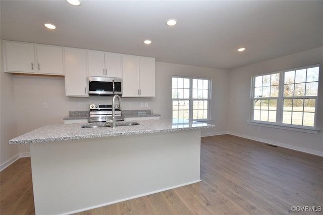 2628 Butterbean Ct, Richmond, VA 23231 - kitchen with stainless steel appliances, a sink, baseboards, white cabinetry, and light wood-style flooring
