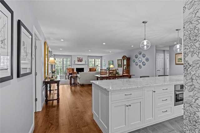 20031 Woodland Fox Ln, Rockville, VA 23146 - kitchen with recessed lighting, light stone countertops, white cabinetry, hanging light fixtures, and dark wood-style flooring