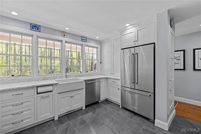 20031 Woodland Fox Ln, Rockville, VA 23146 - kitchen featuring stainless steel appliances, a sink, white cabinetry, baseboards, and light stone counters