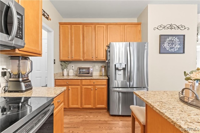 8412 Newbys Mill Dr, Chesterfield, VA 23832 - kitchen with appliances with stainless steel finishes, light wood-type flooring, light stone countertops, and a breakfast bar