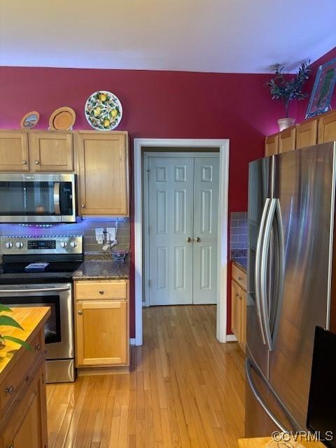 11292 Silverstone Dr, Mechanicsville, VA 23116 - kitchen with stainless steel appliances, light wood-type flooring, dark countertops, and backsplash