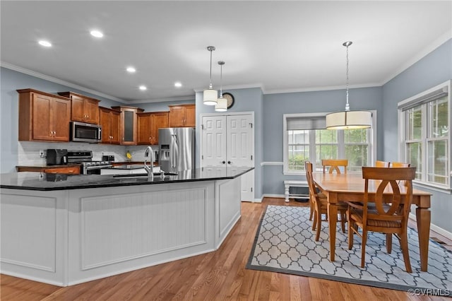 8324 Longlands Pl, Chesterfield, VA 23832 - kitchen featuring stainless steel appliances, a sink, dark countertops, crown molding, and brown cabinets