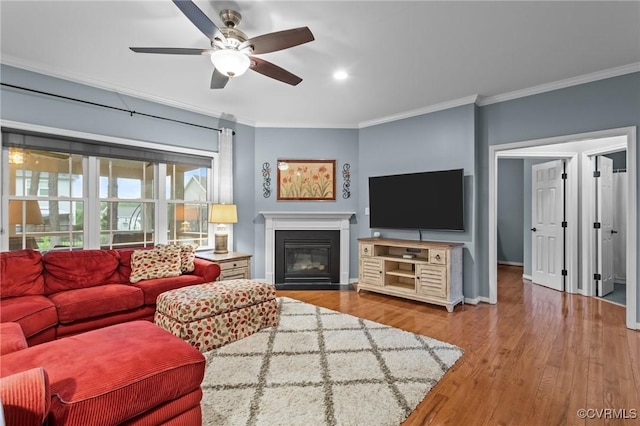 8324 Longlands Pl, Chesterfield, VA 23832 - living room featuring ornamental molding, wood finished floors, a ceiling fan, a glass covered fireplace, and baseboards
