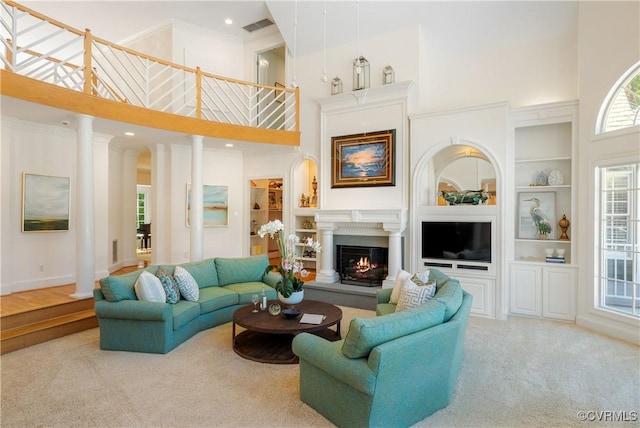 203 Randolph Square Ln, Richmond, VA 23238 - carpeted living area featuring a towering ceiling, built in features, a warm lit fireplace, ornamental molding, and baseboards