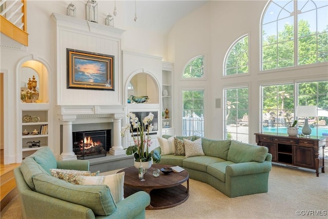 203 Randolph Square Ln, Richmond, VA 23238 - living room featuring a warm lit fireplace, built in features, a high ceiling, and healthy amount of natural light
