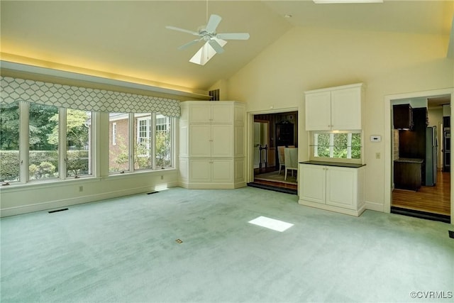 3320 Traylor Dr, Richmond, VA 23235 - unfurnished living room featuring ceiling fan, light colored carpet, high vaulted ceiling, a skylight, and baseboards