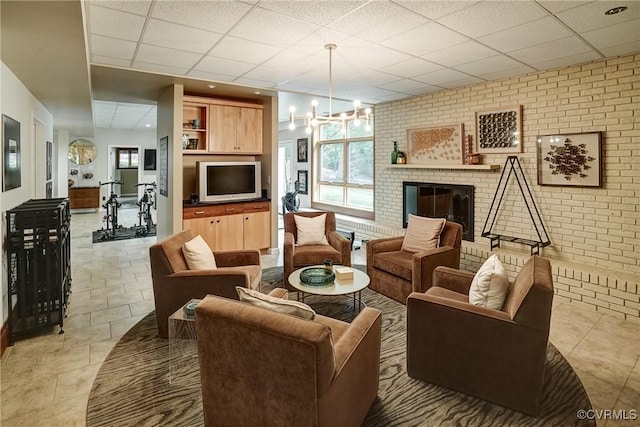 2940 Queenswood Rd, Midlothian, VA 23113 - living area featuring a paneled ceiling, a brick fireplace, light tile patterned floors, and brick wall