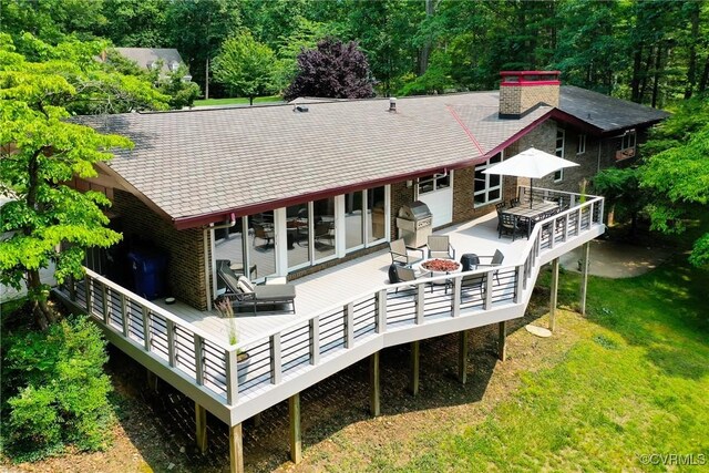 2940 Queenswood Rd, Midlothian, VA 23113 - rear view of house with a lawn, a fire pit, a wooden deck, a chimney, and brick siding