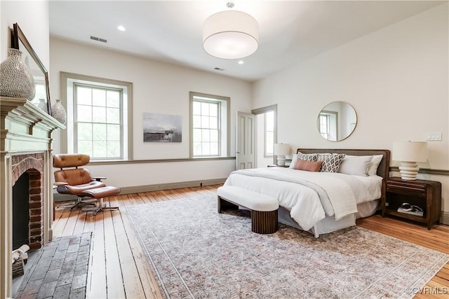 2311 E Broad St, Richmond, VA 23223 - bedroom featuring hardwood / wood-style floors, a brick fireplace, baseboards, and recessed lighting