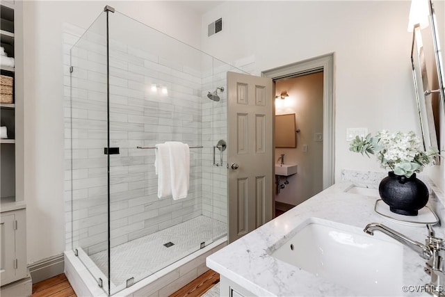 2311 E Broad St, Richmond, VA 23223 - full bathroom featuring a shower stall, double vanity, and wood finished floors