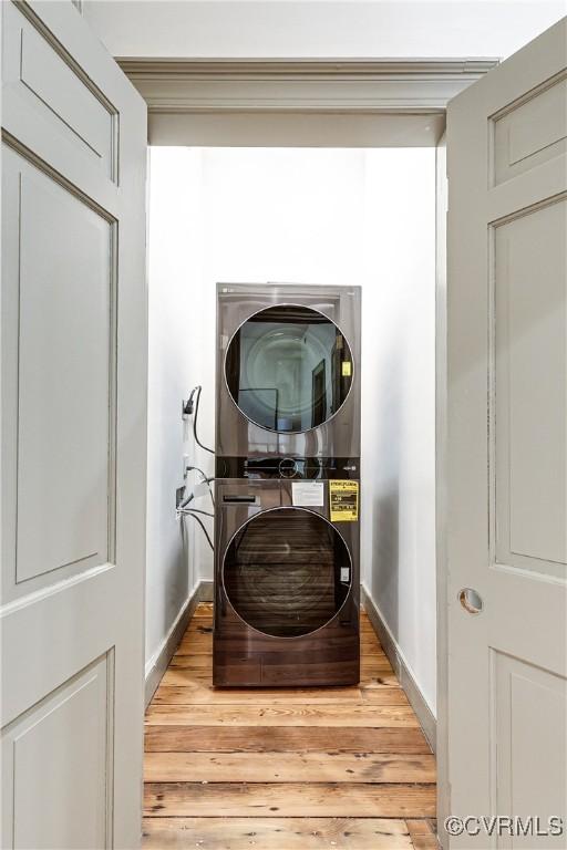 2311 E Broad St, Richmond, VA 23223 - washroom featuring estacked washer and dryer, baseboards, and light wood-style floors