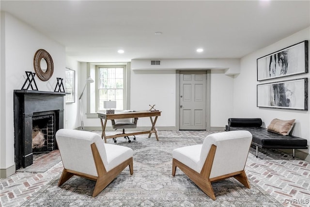 2311 E Broad St, Richmond, VA 23223 - living room featuring brick flooring, a fireplace with raised hearth, recessed lighting, and a desk