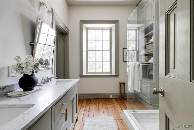 2311 E Broad St, Richmond, VA 23223 - bathroom with double vanity, wood-type flooring, and baseboards