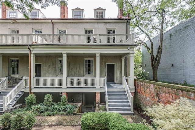 2311 E Broad St, Richmond, VA 23223 - view of front facade featuring stairs, covered porch, stucco siding, and a balcony