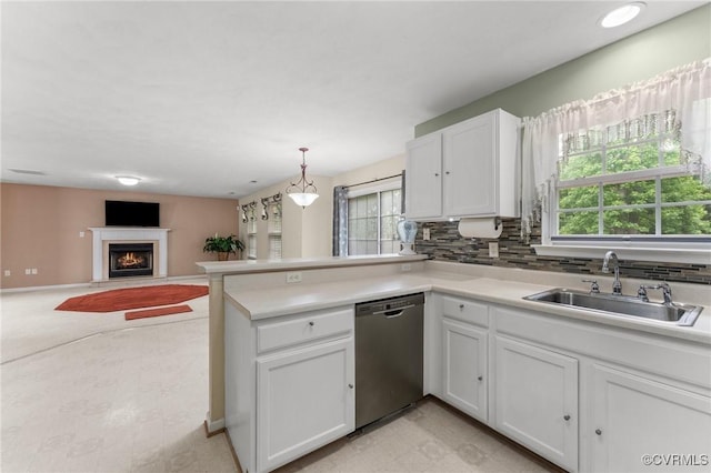 2808 Yellow Wing Ct, Henrico, VA 23231 - kitchen featuring stainless steel dishwasher, a sink, white cabinets, a peninsula, and a warm lit fireplace