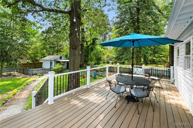 4500 Forest Hill Ave, Richmond, VA 23225 - wooden deck featuring outdoor dining area, an outbuilding, and view of wooded area