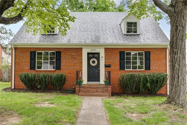 6904 Three Chopt Rd, Richmond, VA 23226 - cape cod house featuring roof with shingles, brick siding, and a front yard