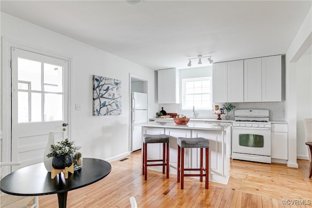6904 Three Chopt Rd, Richmond, VA 23226 - kitchen featuring white appliances, a center island, tasteful backsplash, light countertops, and a kitchen breakfast bar