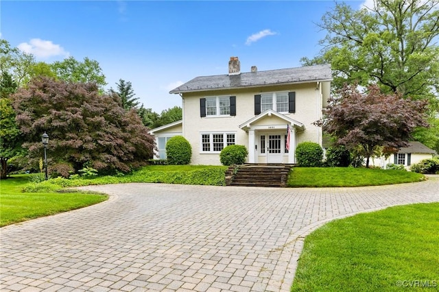 1601 Princeton Rd, Richmond, VA 23227 - colonial house featuring a chimney, a front yard, curved driveway, and stucco siding