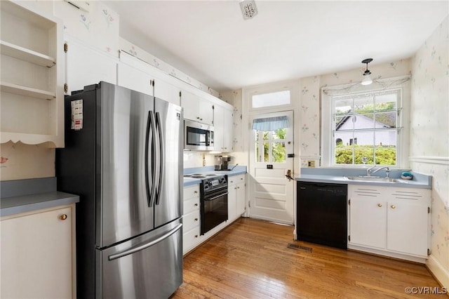 1601 Princeton Rd, Richmond, VA 23227 - kitchen featuring black appliances, light wood-style flooring, white cabinetry, wallpapered walls, and light countertops