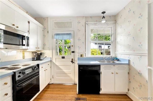 1601 Princeton Rd, Richmond, VA 23227 - kitchen with black appliances, wallpapered walls, a sink, light wood-style flooring, and plenty of natural light