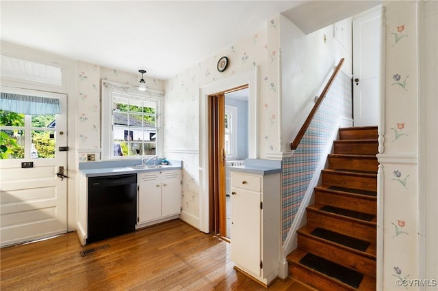 1601 Princeton Rd, Richmond, VA 23227 - kitchen with black dishwasher, wallpapered walls, light wood-type flooring, wainscoting, and light countertops