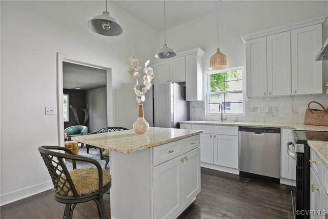 122 Elm St, Petersburg, VA 23803 - kitchen with stainless steel appliances, tasteful backsplash, a sink, a center island, and white cabinetry