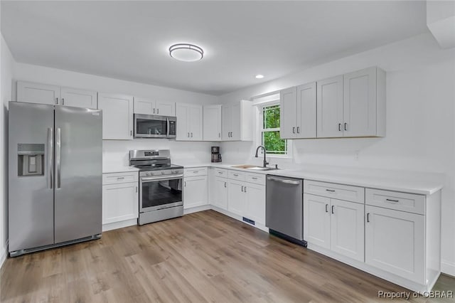 647 Lakeview Dr, Heathsville, VA 22473 - kitchen with appliances with stainless steel finishes, a sink, light countertops, wood finished floors, and white cabinetry