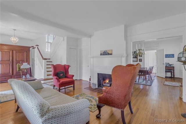 159 Fleeton Point Cir, Reedville, VA 22539 - living area featuring a chandelier, stairway, light wood finished floors, and a fireplace with flush hearth