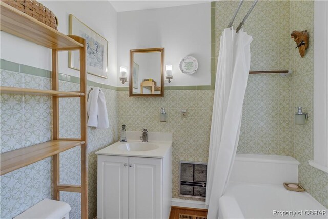 159 Fleeton Point Cir, Reedville, VA 22539 - bathroom with vanity, shower / tub combo with curtain, a wainscoted wall, and toilet