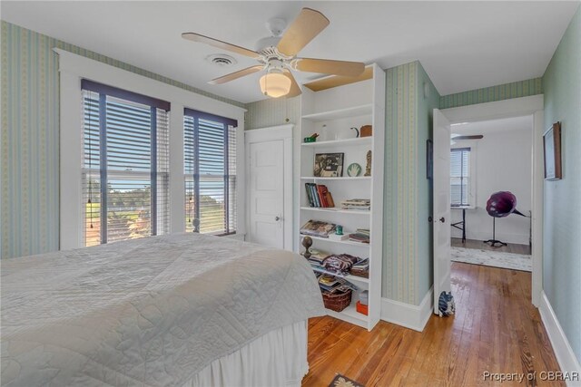 159 Fleeton Point Cir, Reedville, VA 22539 - bedroom with wood finished floors, wallpapered walls, baseboards, and a ceiling fan